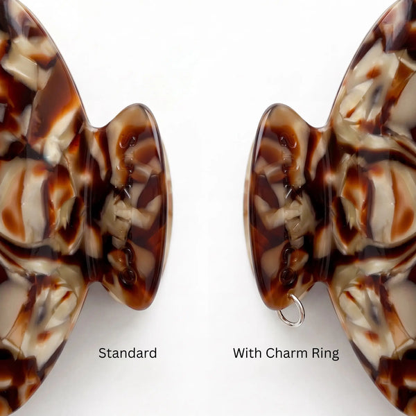 Two close up views of a tortoiseshell  hair claw clip handle on a white background, labeled 'Standard' and 'With Charm Ring' to show the included silver ring attachment charm.