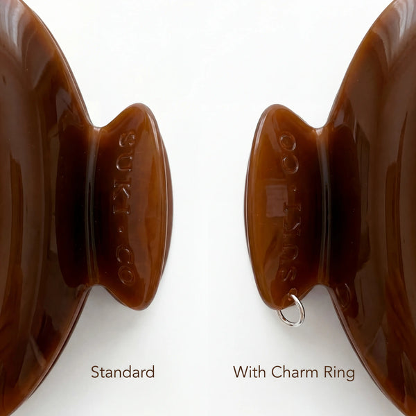 A close up of 2 claw clip handles showing one with a charm ring attached. Displayed with the label standard and with charm ring under each claw clip handle.