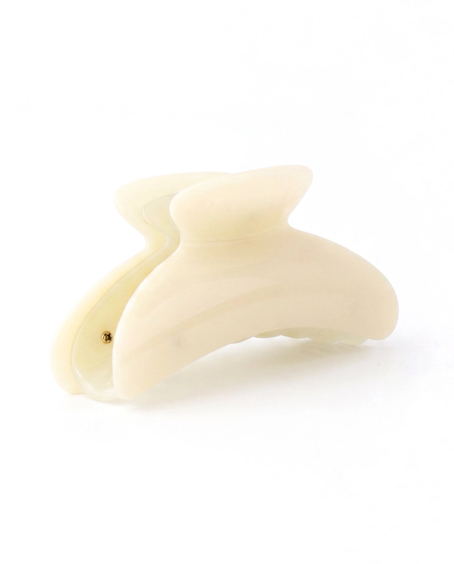 A single cream-colored hair claw clip shown on a seamless white background.