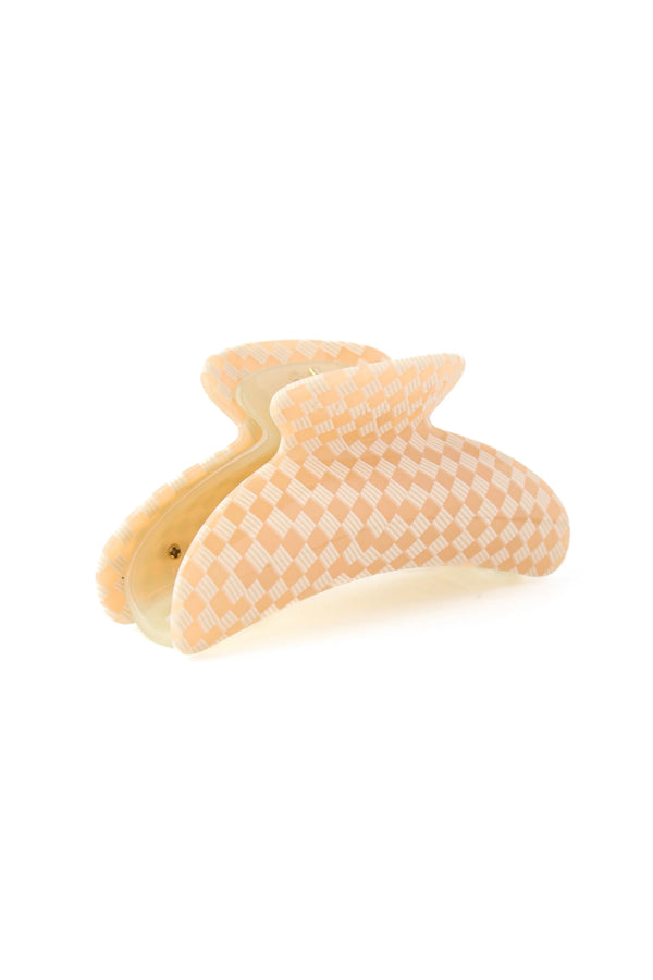 A peach and white checkered claw hair clip on a solid white background.